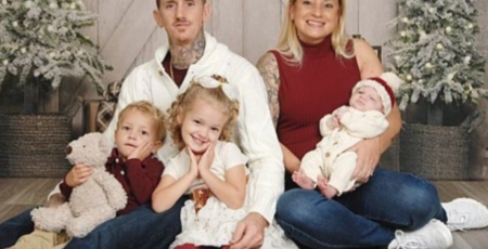 father, mother, and 3 young children pose for a holiday portrait