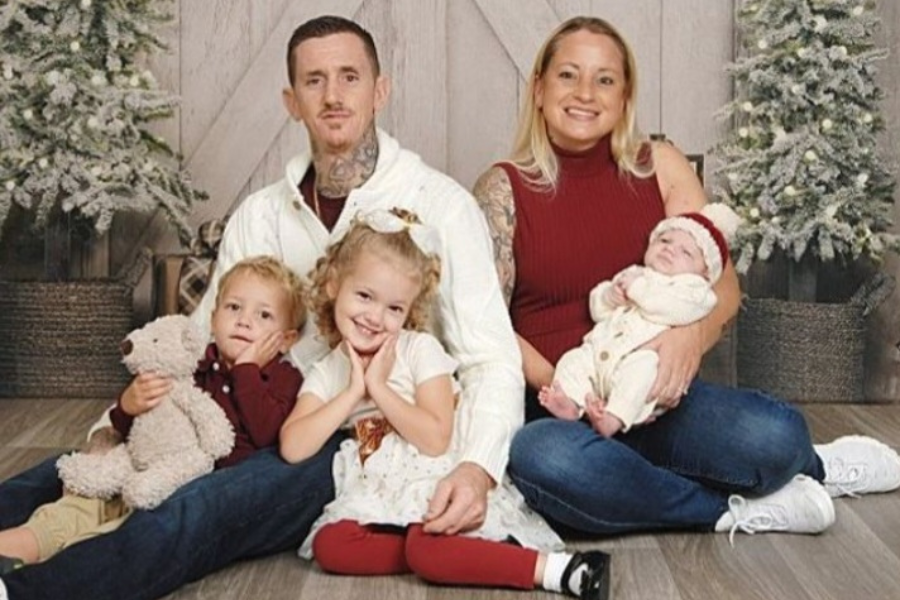father, mother, and 3 young children pose for a holiday portrait