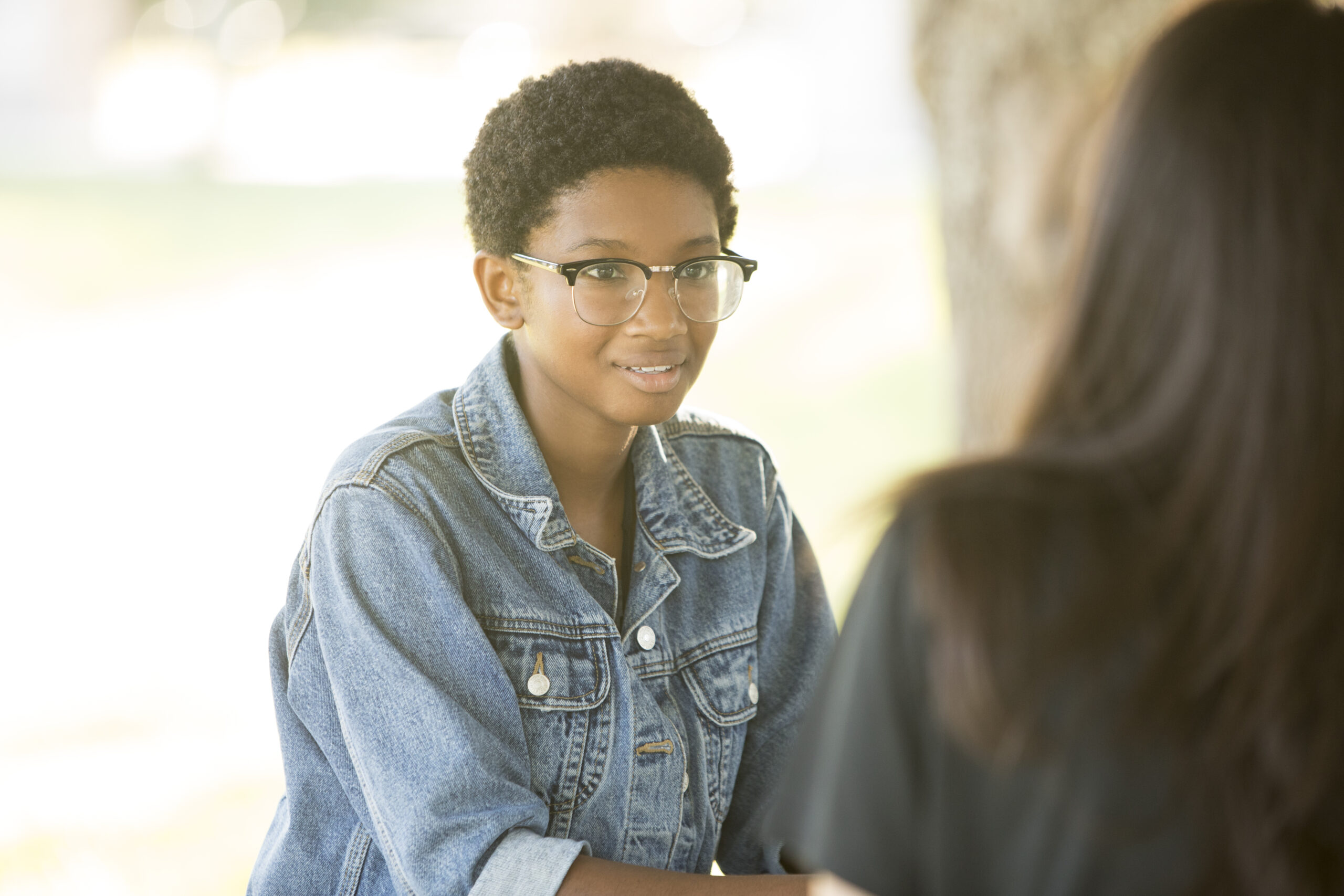 girl with glasses talking to another person